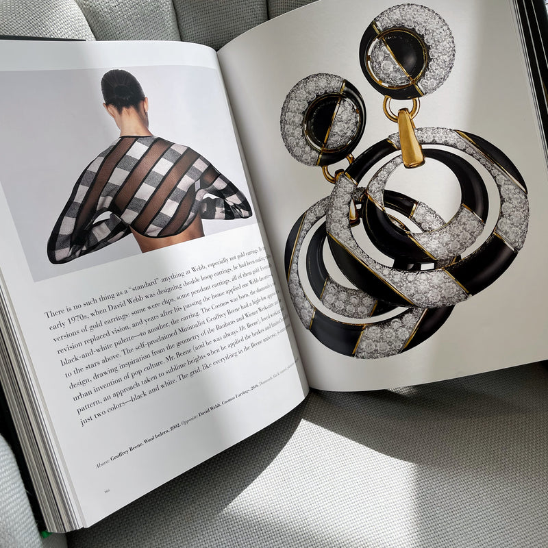 open coffee table book with pages showing black and white designs in fashion and jewelry