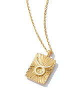 gold pendant with Taurus zodiac sign on 18k gold chain necklace shown against white background
